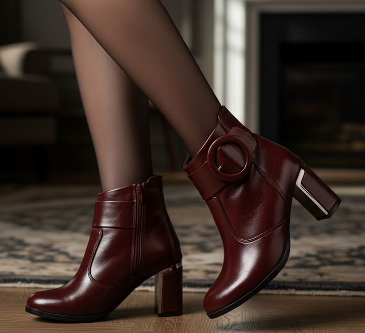 Brown leather ankle boots worn indoors on a wooden floor.