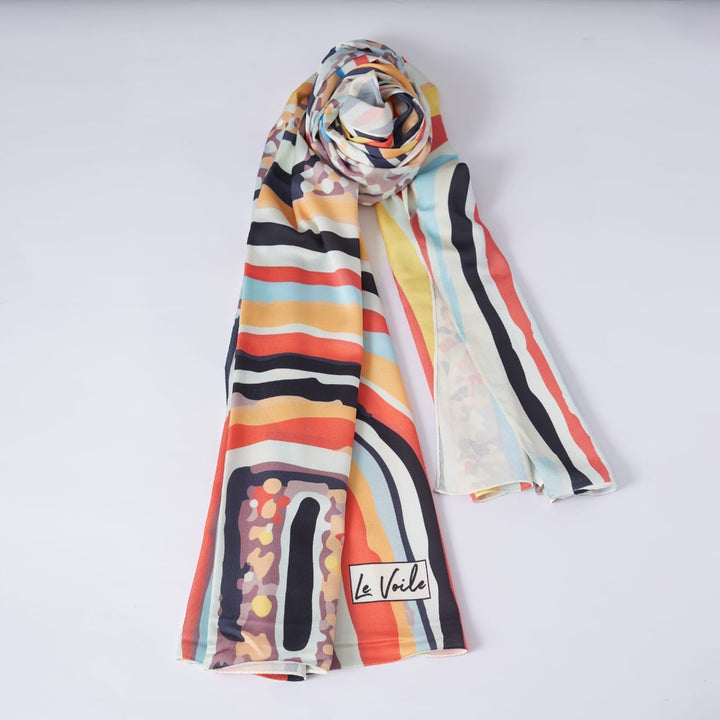 Colorful striped scarf with 'Le Voile' branding on a white background