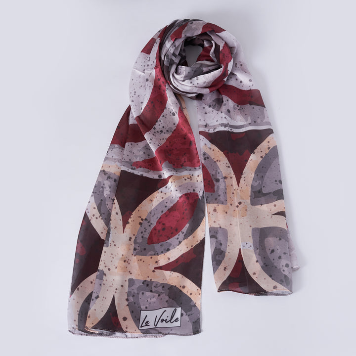 Patterned scarf with 'La Voile' branding on a light gray background